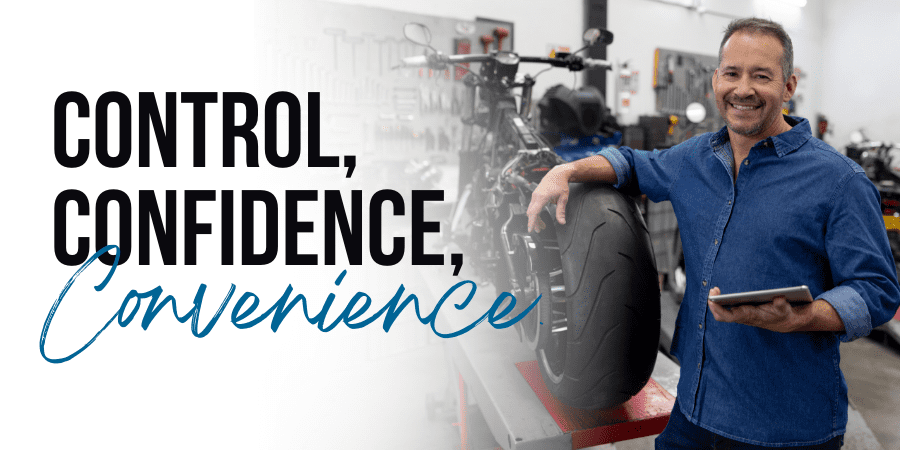 A smiling middle aged man in a motorcycle shop holding a tablet. At the left, the words: control, confidence, convenience.