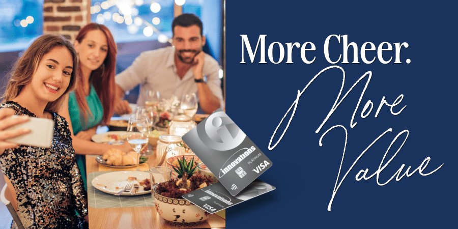 A group of friends taking a picture at a holiday dinner table. At the center, two Innovations credit cards. At the right, the words: more cheer more value