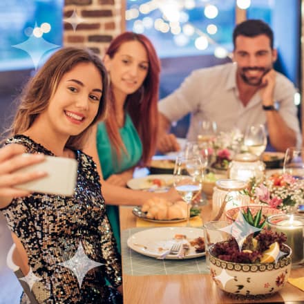 A party of three taking a picture at a holiday dinner table.