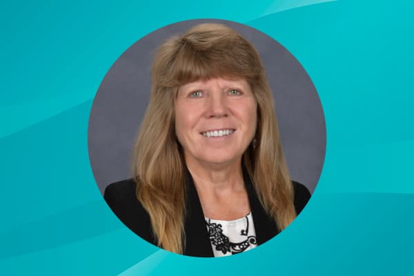 Profile of Sharon Frost against a patterned background.