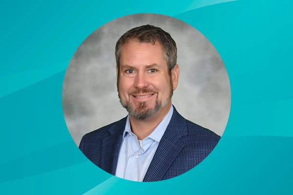 Profile of Josh Scribner against a patterned background.