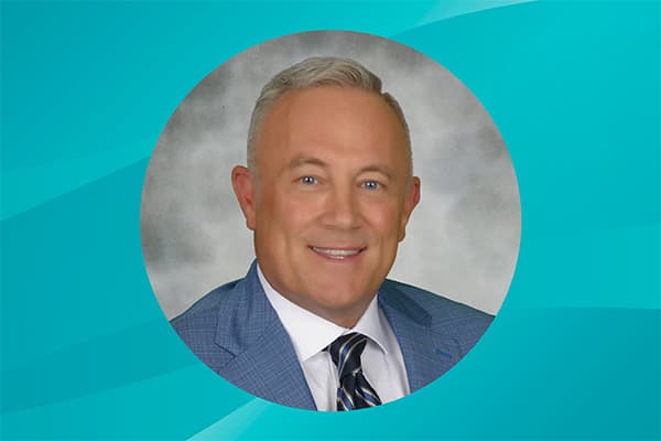 Profile of Scott Gladden against a patterned background.