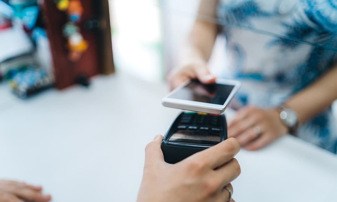 A person using a smart wallet on a mobile phone to pay.