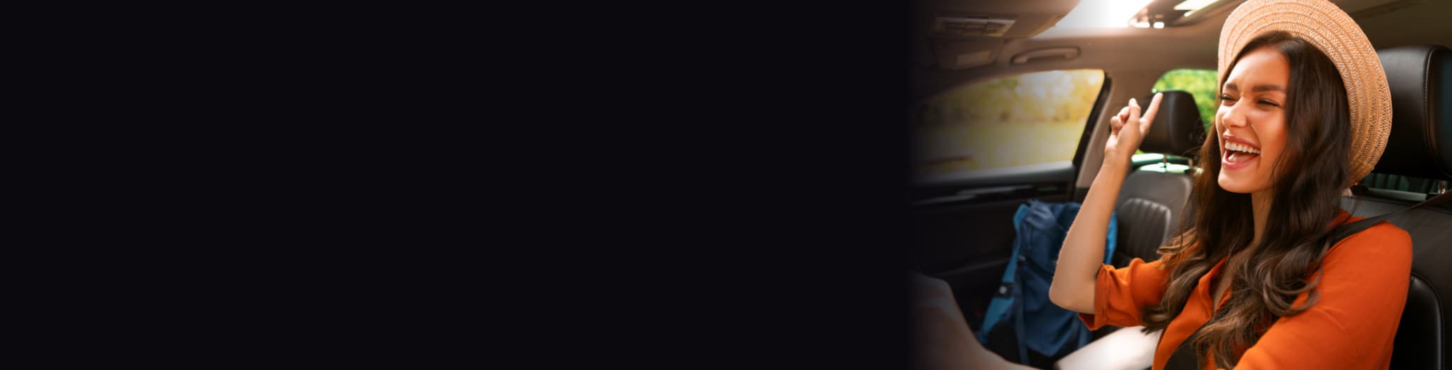 A happy young woman singing inside her car.